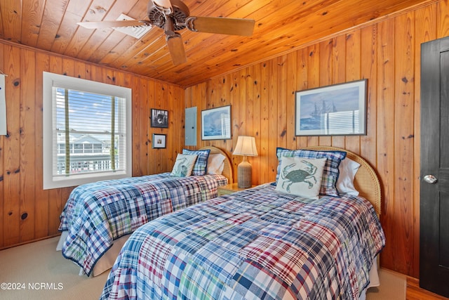 bedroom with wooden walls, wooden ceiling, ceiling fan, and carpet flooring