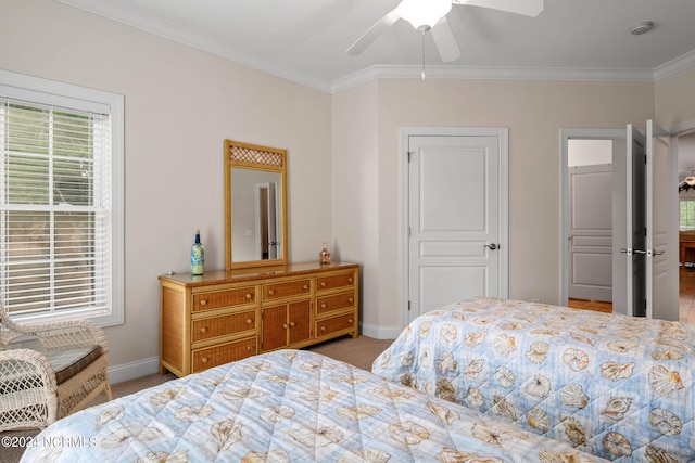 carpeted bedroom featuring crown molding and ceiling fan