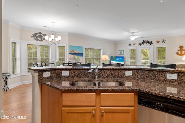 kitchen with dishwasher, dark stone counters, light hardwood / wood-style floors, sink, and ornamental molding