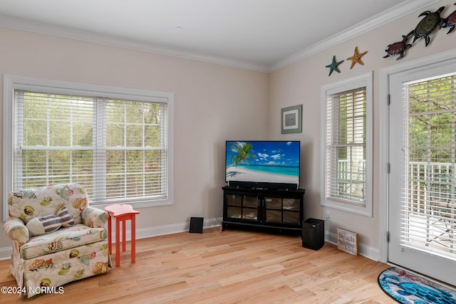 sitting room with light hardwood / wood-style floors and crown molding