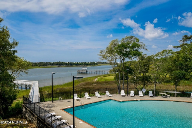 view of swimming pool featuring a patio area and a water view