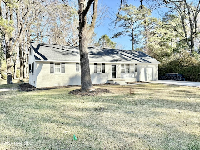 ranch-style home featuring a garage and a front lawn