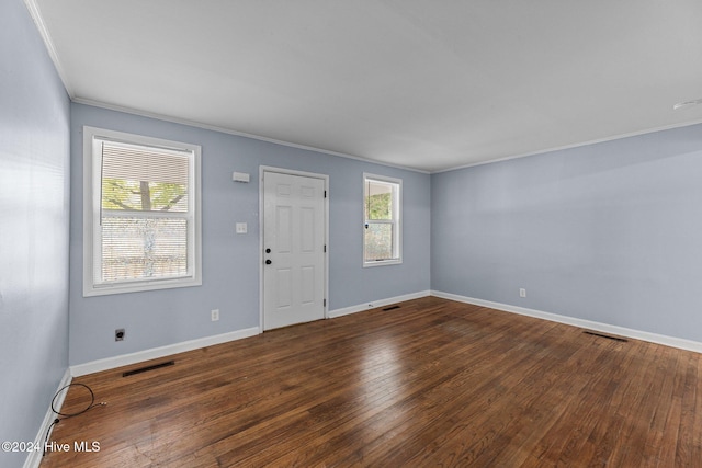 empty room with crown molding and dark wood-type flooring