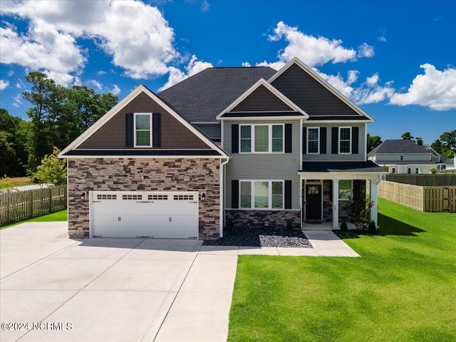 craftsman inspired home featuring a garage and a front lawn