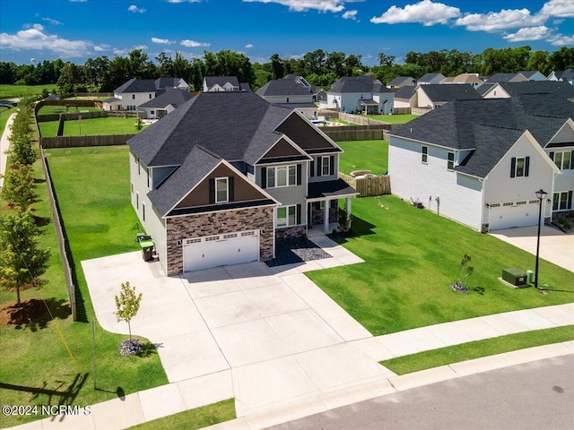 craftsman-style house featuring a garage, a front lawn, and cooling unit