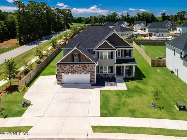 craftsman house with a garage and a front lawn