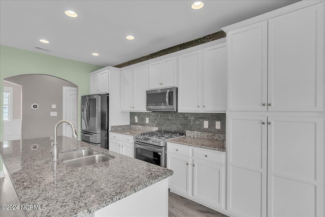 kitchen featuring appliances with stainless steel finishes, light wood-type flooring, white cabinets, and sink