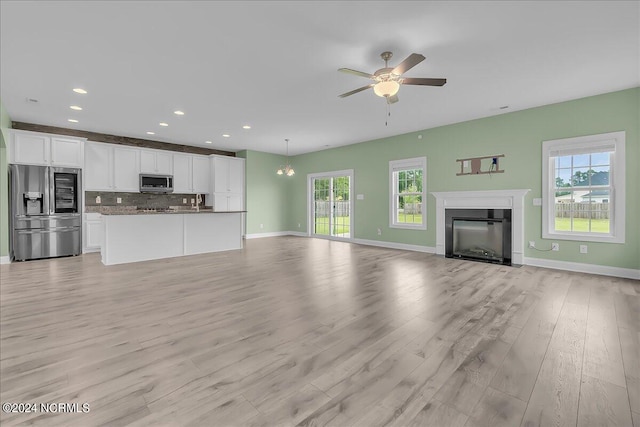 unfurnished living room with ceiling fan and light hardwood / wood-style flooring