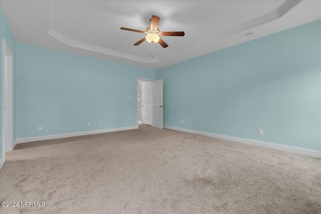 spare room featuring carpet flooring, ceiling fan, and a raised ceiling