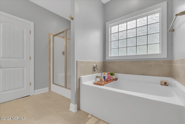 bathroom with tile patterned flooring and separate shower and tub