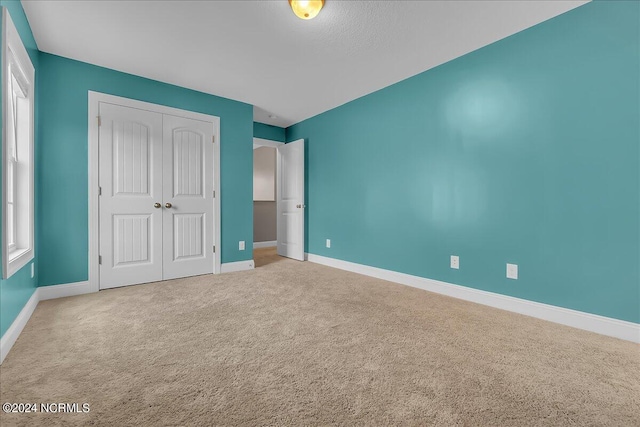 unfurnished bedroom with a closet and carpet floors