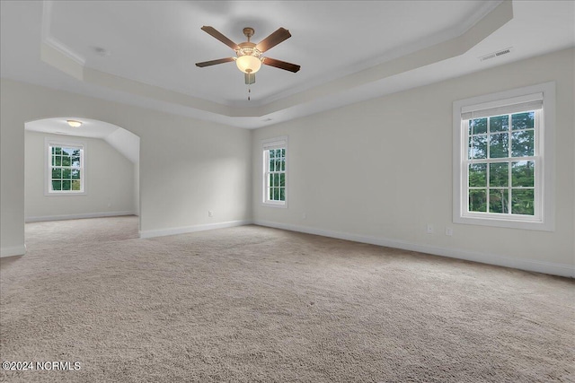 unfurnished room with carpet flooring, ceiling fan, and a raised ceiling