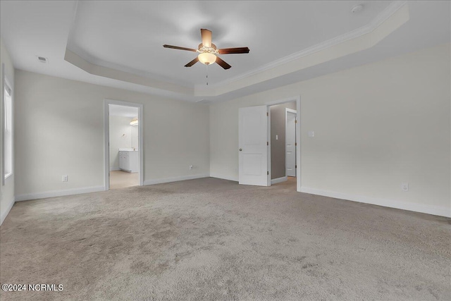 unfurnished room featuring light carpet, a raised ceiling, crown molding, and ceiling fan