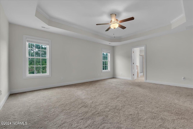 unfurnished room with crown molding, ceiling fan, a raised ceiling, and carpet flooring