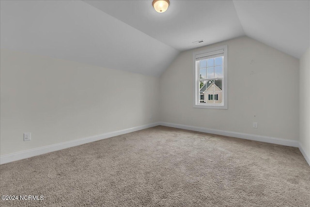 additional living space with lofted ceiling and carpet flooring