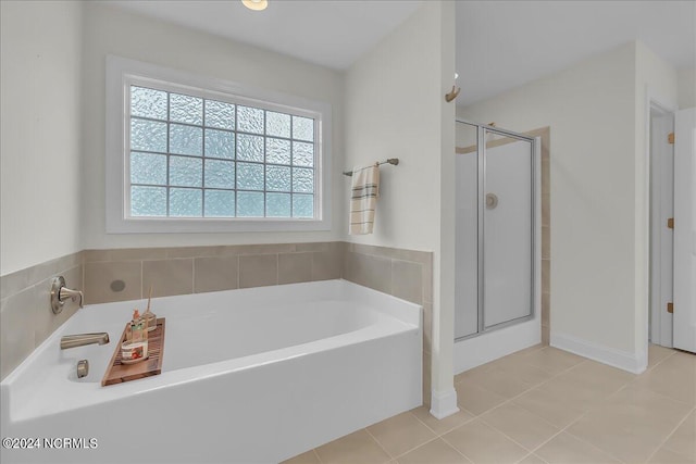 bathroom with tile patterned floors, shower with separate bathtub, and a wealth of natural light