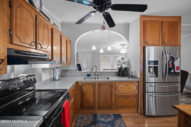 kitchen with under cabinet range hood, a sink, black electric range, brown cabinets, and stainless steel fridge