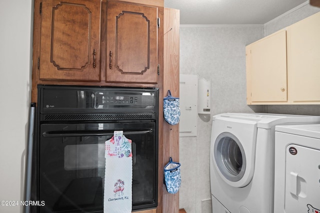 washroom featuring wallpapered walls, washing machine and dryer, cabinet space, and crown molding