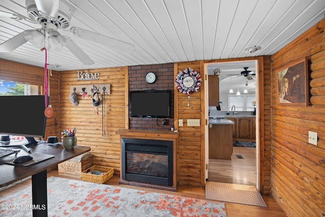 home office featuring wood ceiling, wood finished floors, log walls, a fireplace, and a sink