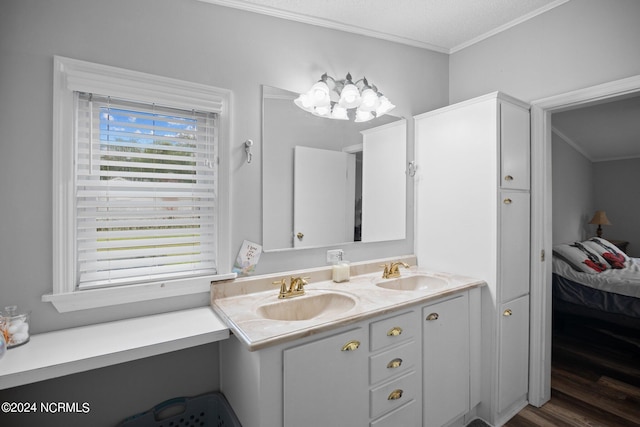 ensuite bathroom featuring crown molding, a sink, and double vanity