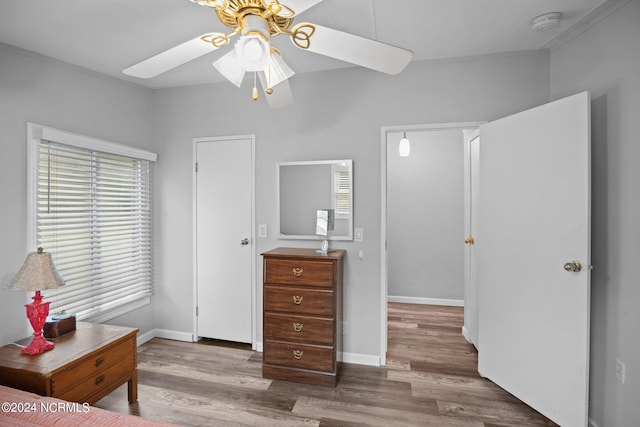 bedroom with a ceiling fan, baseboards, and wood finished floors