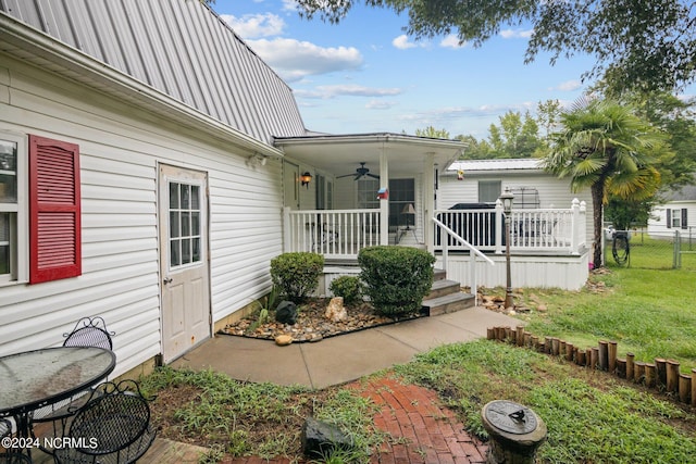 exterior space with covered porch, a lawn, metal roof, ceiling fan, and fence