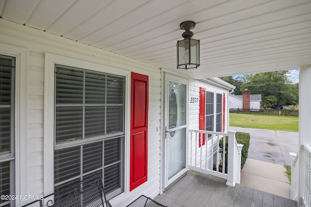 view of exterior entry featuring a yard and fence