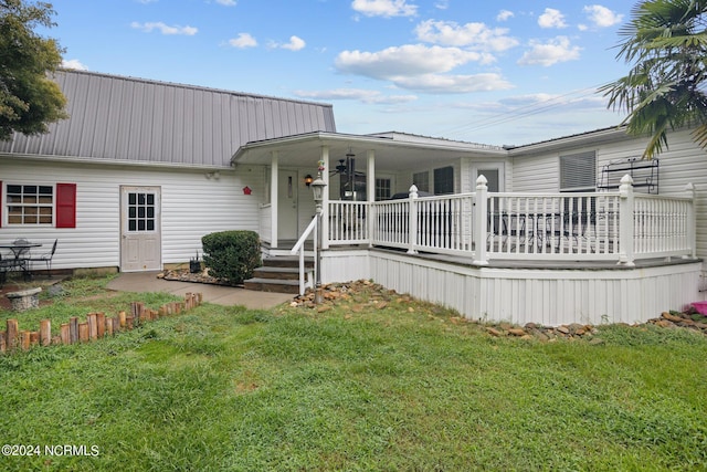 view of front of home featuring a porch, metal roof, and a front lawn