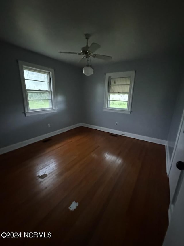 spare room featuring hardwood / wood-style flooring, plenty of natural light, and ceiling fan