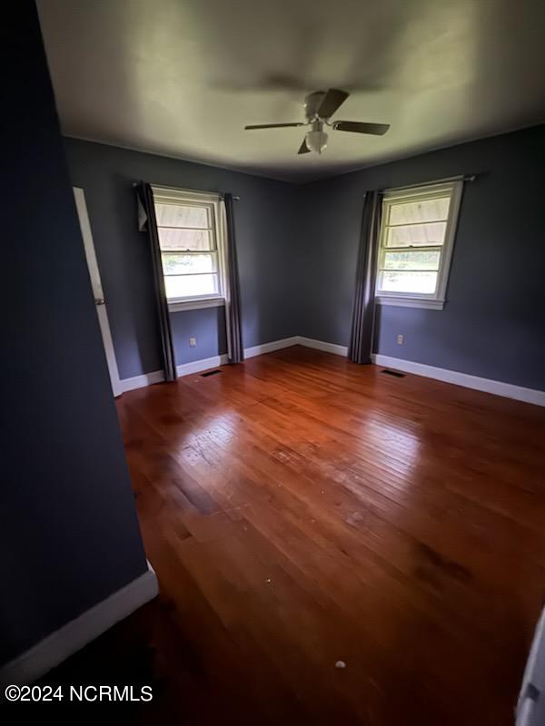 empty room featuring wood-type flooring and ceiling fan