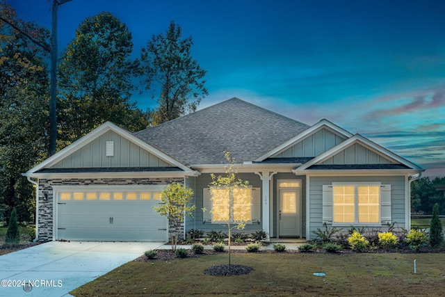 craftsman-style house featuring a garage and a lawn