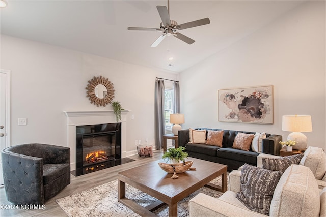 living room featuring lofted ceiling, ceiling fan, and light hardwood / wood-style flooring