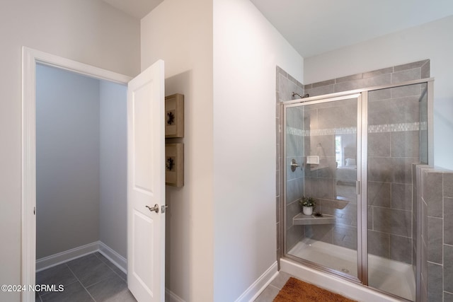 bathroom with a shower with shower door and tile patterned floors