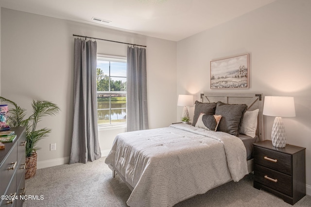 carpeted bedroom featuring a water view