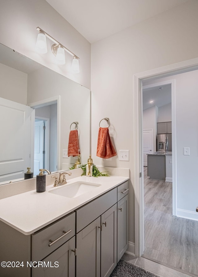 bathroom featuring hardwood / wood-style flooring, lofted ceiling, and vanity