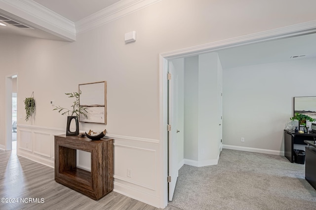 hallway featuring ornamental molding and light carpet