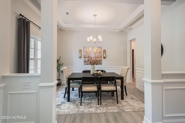 dining space with light hardwood / wood-style floors, crown molding, and a notable chandelier