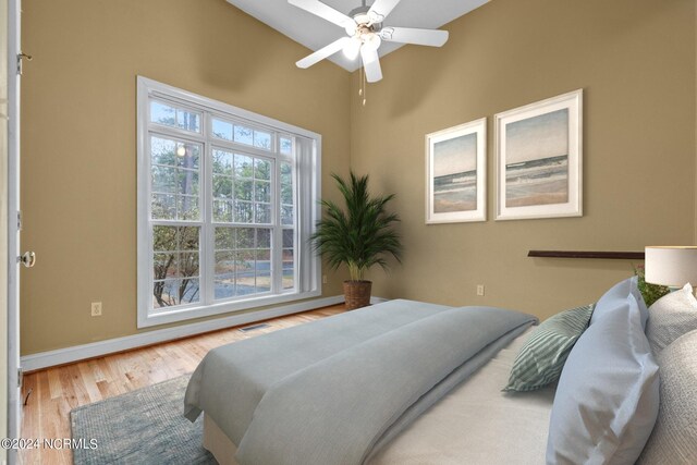 bedroom with ceiling fan, vaulted ceiling, and hardwood / wood-style flooring