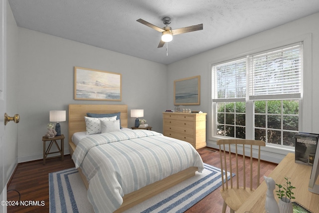 bedroom featuring ceiling fan, dark hardwood / wood-style flooring, and a textured ceiling