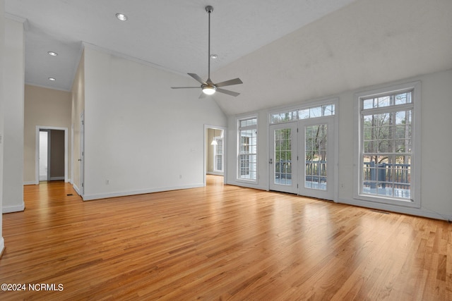 unfurnished living room with ceiling fan, light hardwood / wood-style floors, high vaulted ceiling, and french doors