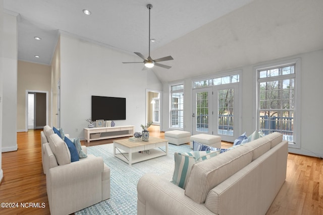 living room with ceiling fan, french doors, high vaulted ceiling, and light hardwood / wood-style flooring