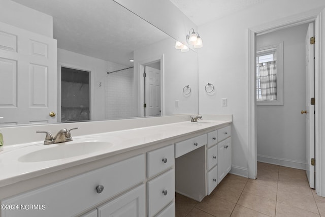 bathroom featuring a tile shower, tile patterned flooring, vanity, and a textured ceiling