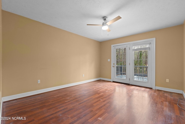 empty room with ceiling fan, dark wood-type flooring, and a textured ceiling