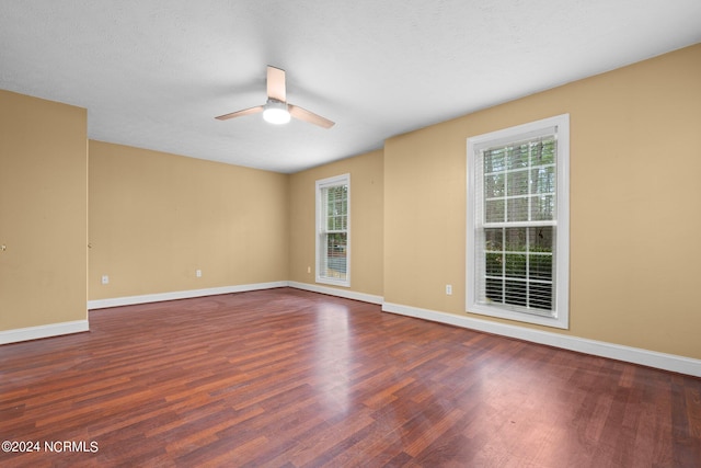 unfurnished room with dark hardwood / wood-style floors and ceiling fan