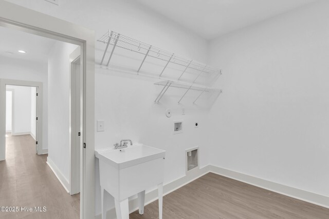 kitchen with light wood-type flooring, gray cabinets, stainless steel microwave, backsplash, and light countertops