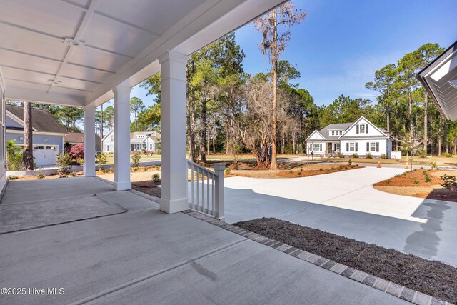 doorway to property with covered porch and a shingled roof