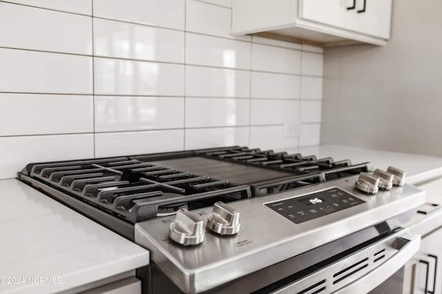 room details with white cabinetry, light countertops, stainless steel range with gas stovetop, and tasteful backsplash