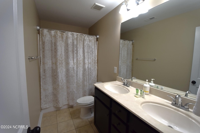 bathroom featuring dual vanity, toilet, and tile patterned floors