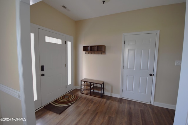 foyer entrance featuring baseboards, visible vents, and wood finished floors