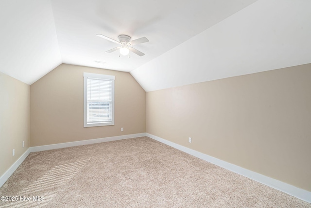 additional living space featuring ceiling fan, light colored carpet, and vaulted ceiling